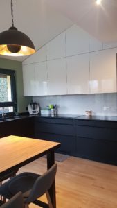 Conception et installation d'une cuisine moderne noir et blanc avec agencement de rangements.